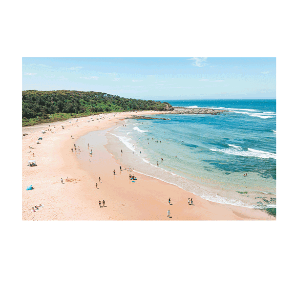 A breathtaking aerial view of Bateau Bay, NSW, featuring a crescent-shaped sandy beach, turquoise waters, and a lush green headland. The coastal landscape is dotted with beachgoers, and the waves gently lap against the rocky shoreline.