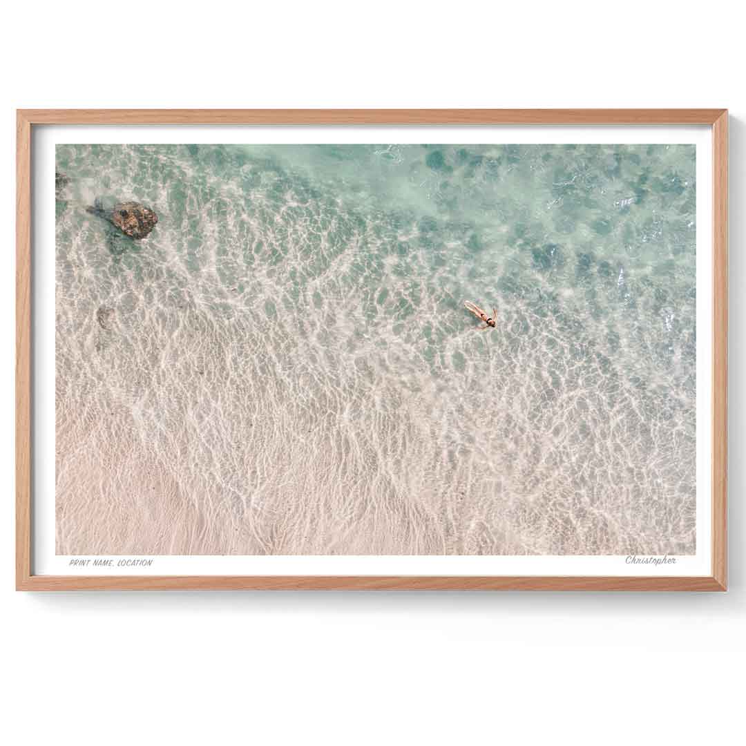Framed artwork of a beach scene with waves and a wooden frame.