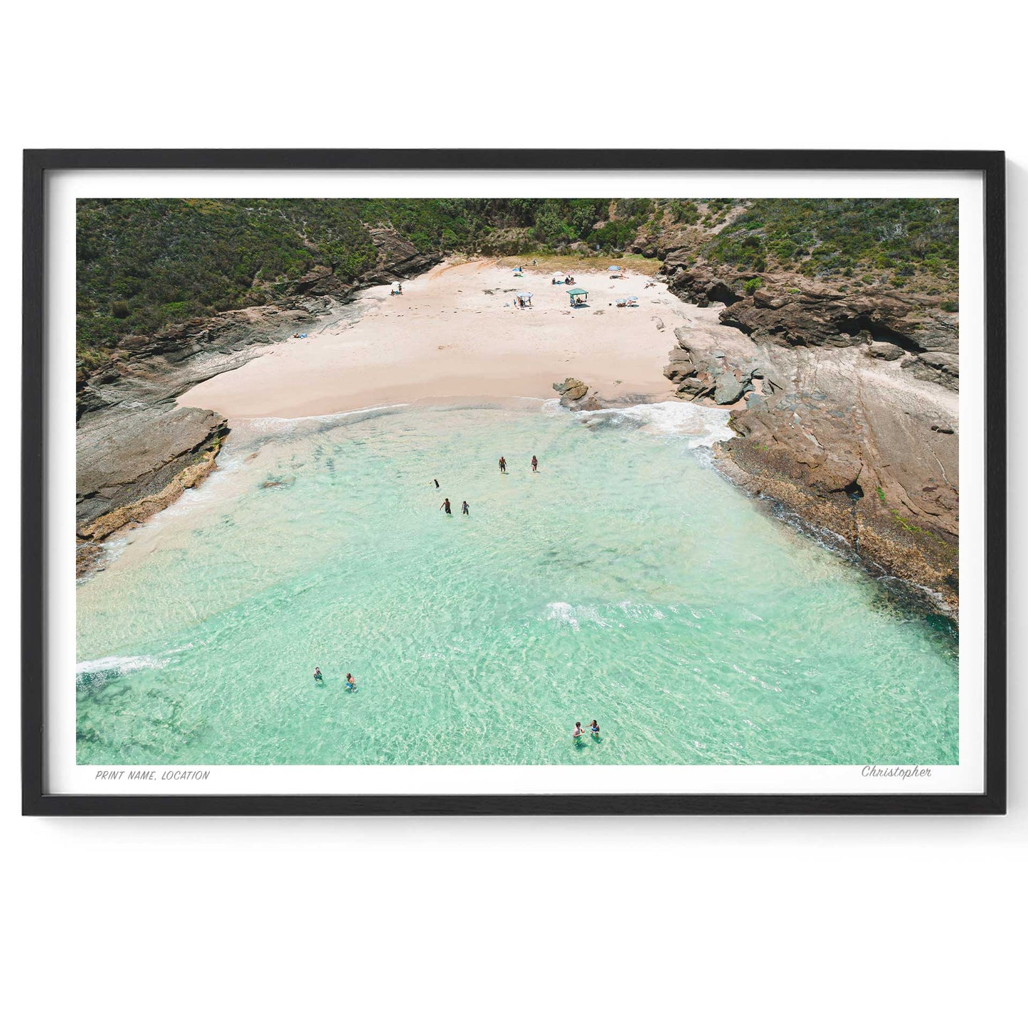 Framed artwork of a beach scene with clear water and people swimming.