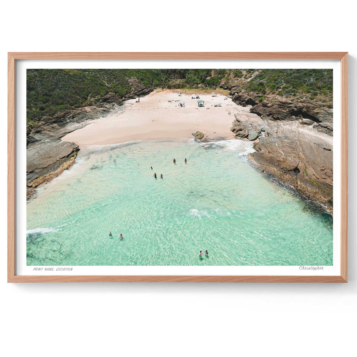 Framed photograph of a beach with clear turquoise water and sandy shore.