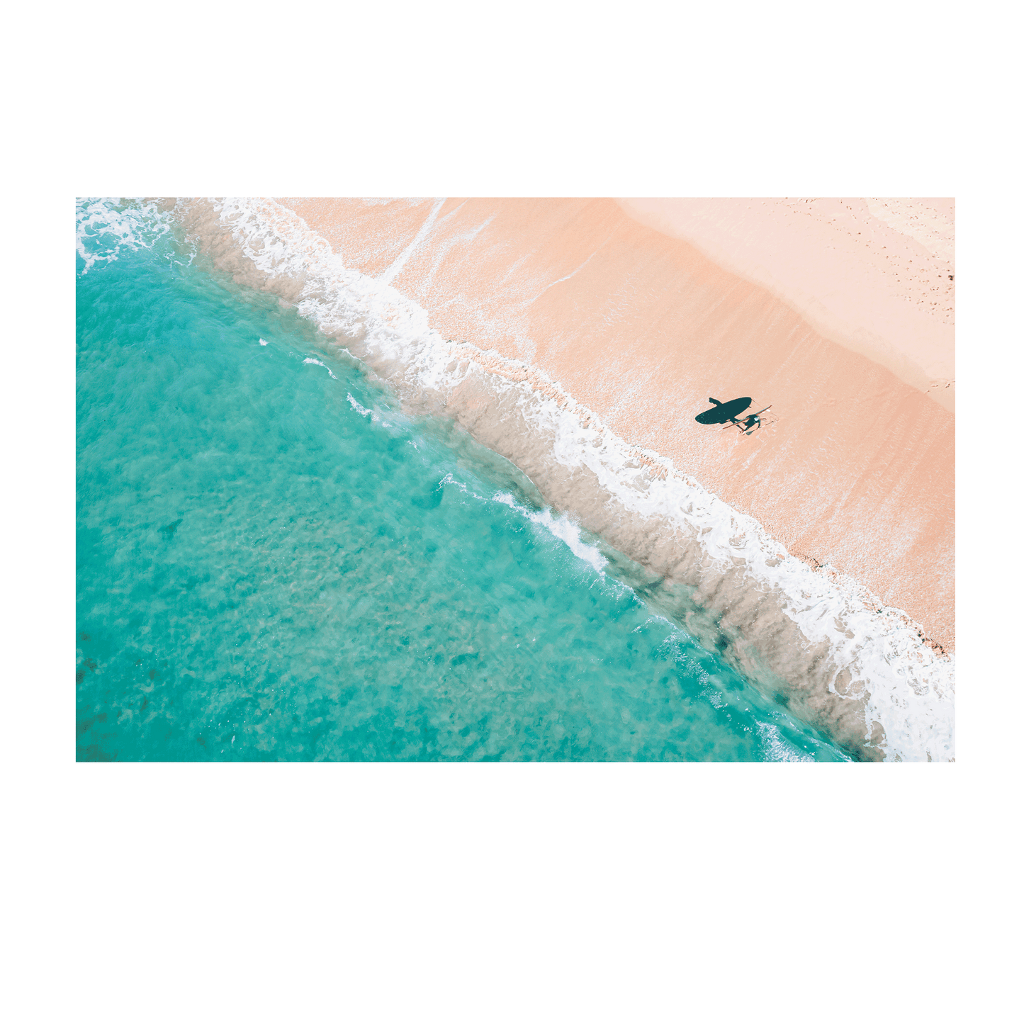 An aerial view of Blue Bay, NSW, showcasing soft waves, golden sand, and a surfer with their board casting a shadow on the shoreline.