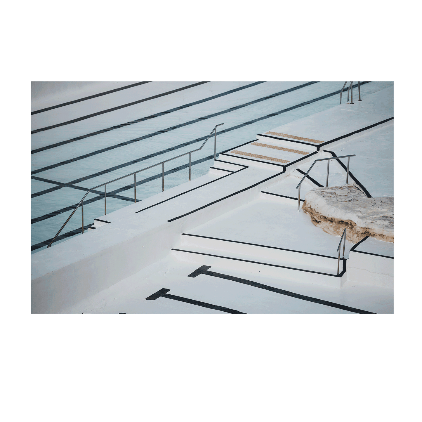 A minimalist architectural view of Bondi’s ocean pool, showcasing crisp white surfaces, geometric shadows, and deep lane markings.