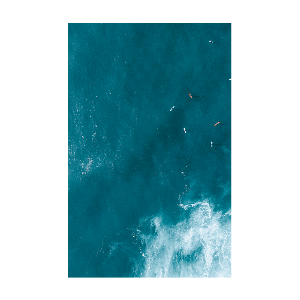 Aerial view of waves swirling over golden sands at Forresters Beach, NSW, creating a dynamic and abstract ocean scene.