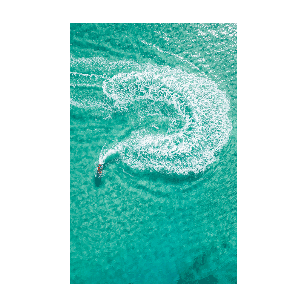 A jet ski carving a perfect swirl in the turquoise waters off Frazer Beach, NSW, leaving a foamy white trail.