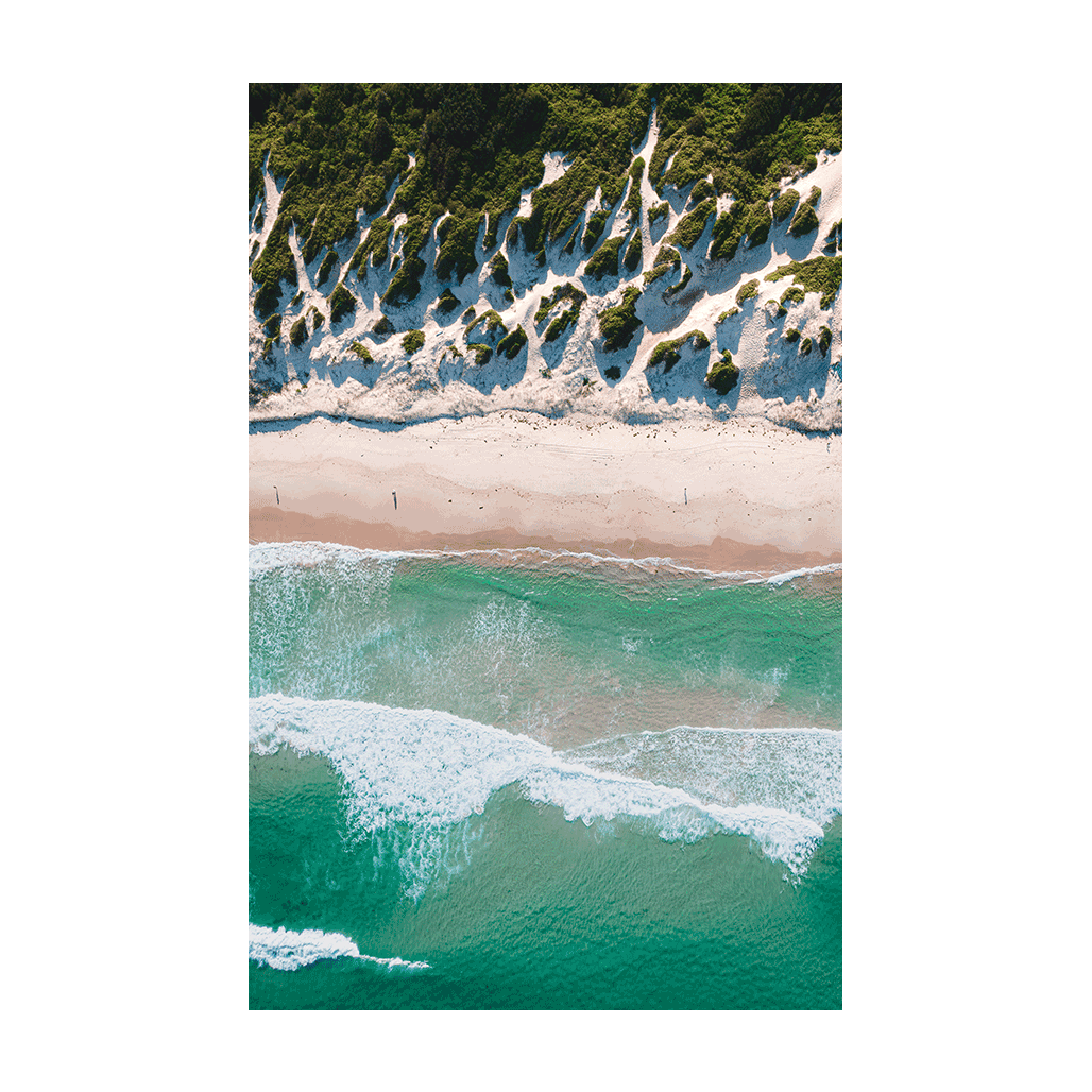 A stunning aerial view of Soldiers Beach, Norah Head, NSW, featuring rolling green dunes, soft white sand, and turquoise ocean waves.