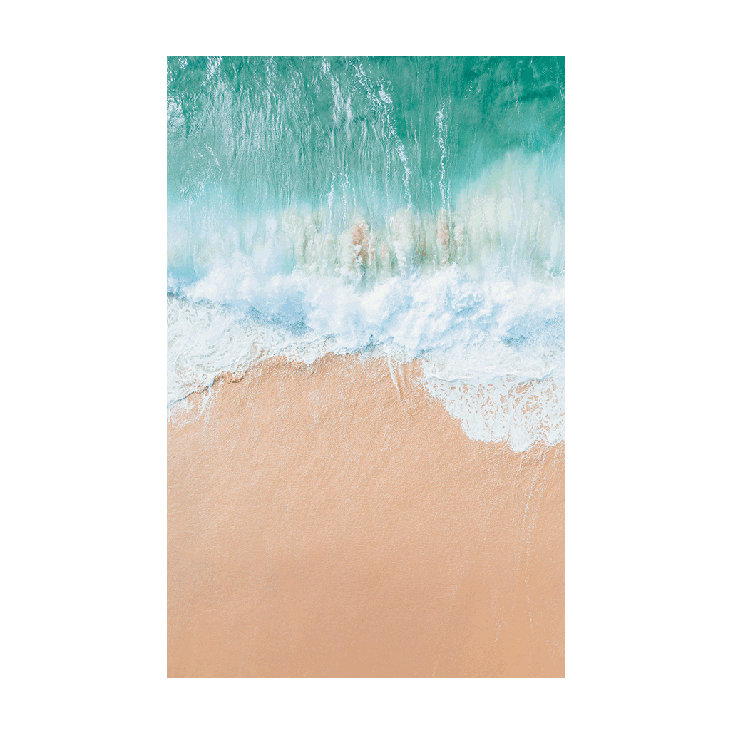 An aerial view of Spoon Bay, Central Coast, capturing powerful turquoise waves crashing onto soft golden sands in a perfect land-sea balance.