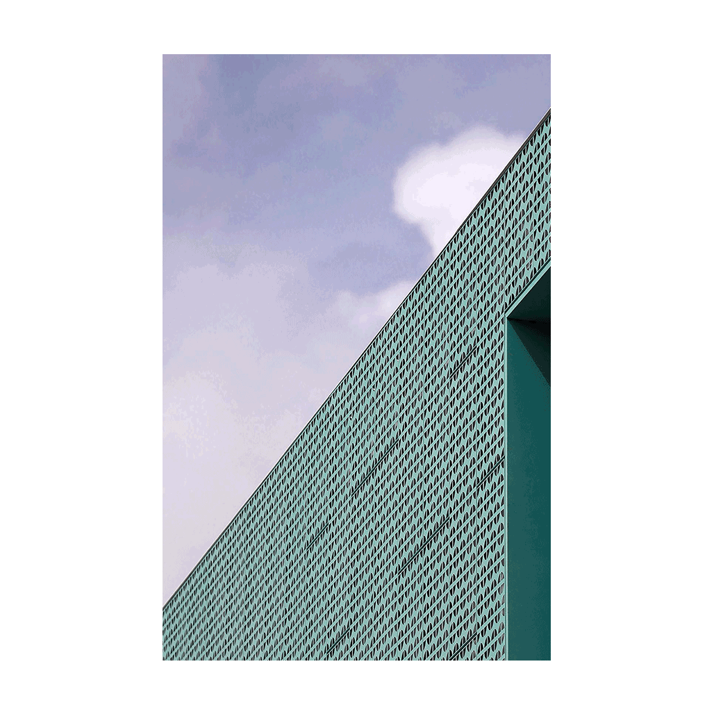 A modern architectural facade in Sydney featuring a geometric perforated design with sharp angles against a soft sky.