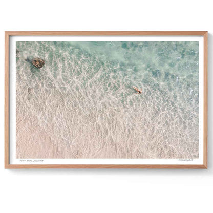 Framed artwork of a beach scene with waves and a wooden frame.