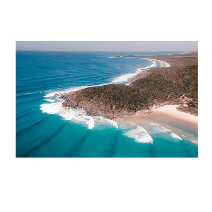 Aerial view of Big Hill Beach at Crescent Head, NSW, showcasing turquoise waters, rolling waves, and a rugged coastal landscape.

