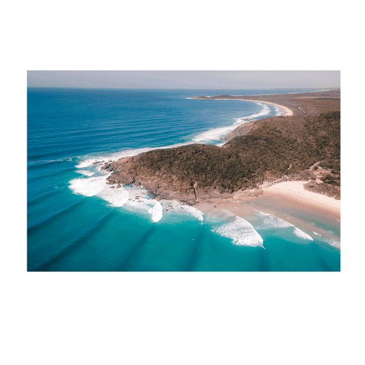 Aerial view of Big Hill Beach at Crescent Head, NSW, showcasing turquoise waters, rolling waves, and a rugged coastal landscape.
