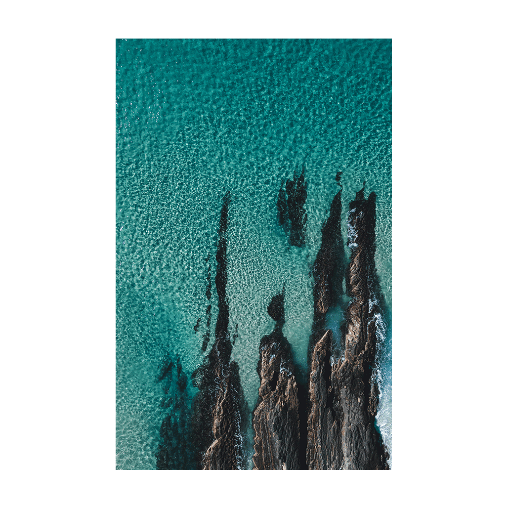 A stunning aerial coastal print of Forster, NSW, showcasing jagged rock formations emerging through clear turquoise waters.