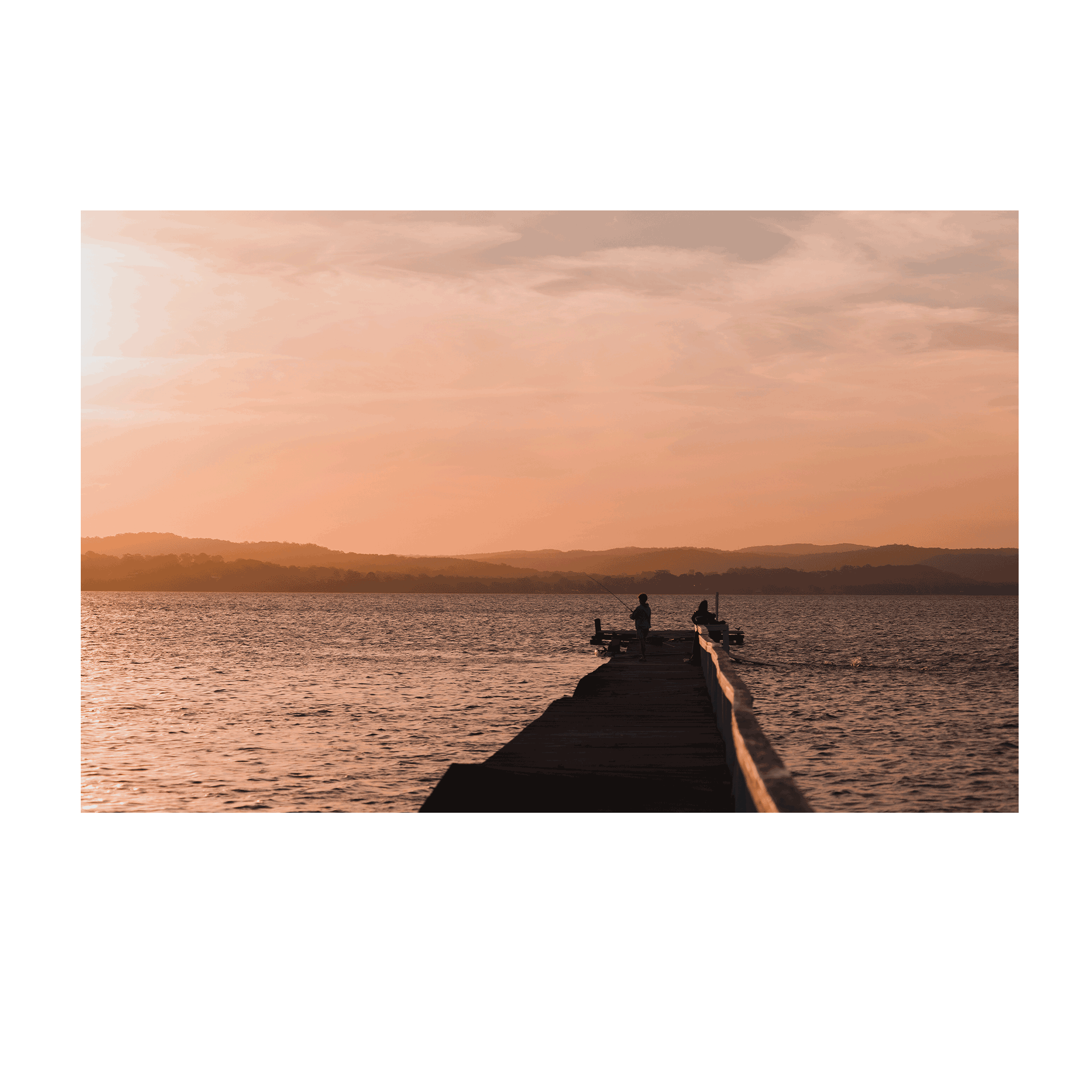 A tranquil sunset scene at Long Jetty, NSW, featuring silhouetted figures fishing against a golden sky reflecting on calm waters.
