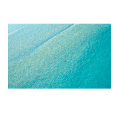 Aerial view of crystal-clear turquoise waters at Terrigal Beach, NSW, showcasing gentle ripples and shifting ocean hues.

